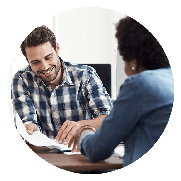 Picture of a man smiling while he reviews paperwork with a woman