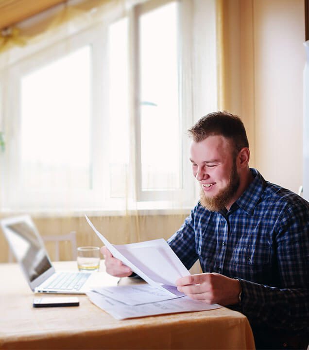 Picture of a man smiling and reviewing a document